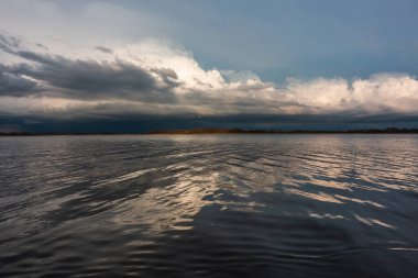 Gölü ve bulutlu gökyüzü olan güzel bir manzara. 