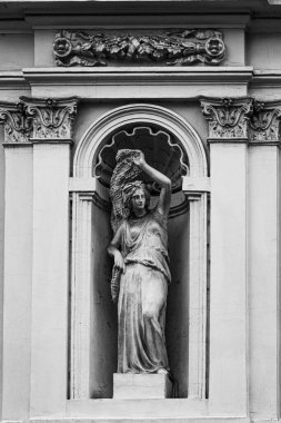 heykeli olan eski binanın siyah beyaz fotoğrafı. 