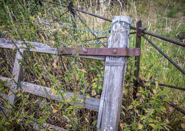 Old Broken Wooden Gate Metal Hinge Barbed Wire Resting Metal — Zdjęcie stockowe