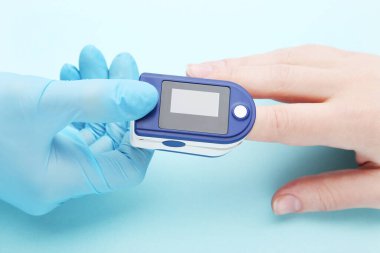 Doktor insan parmağında nabız oksimetresi testi uygular.