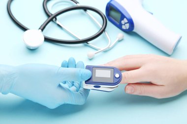 Doktor insan parmağında nabız oksimetresi testi uygular.