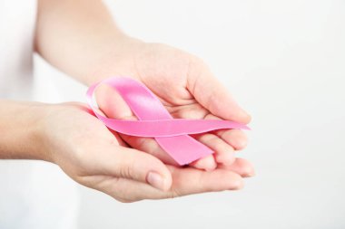 Göğüs kanseri konsepti. Pembe kurdeleli kadın elleri