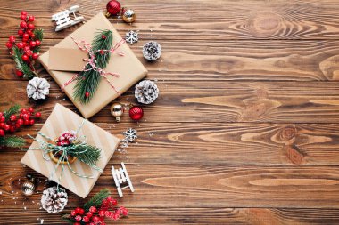 Kahverengi ahşap arka planda süslemeleri olan hediye kutuları