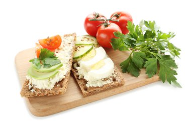 Krem peynirli çıtır ekmek, beyaz arka planda yumurta ve sebze.