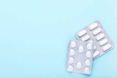 Mavi arka planda su toplayan beyaz haplar.