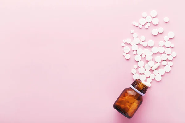 粉红背景的药丸和药瓶 — 图库照片