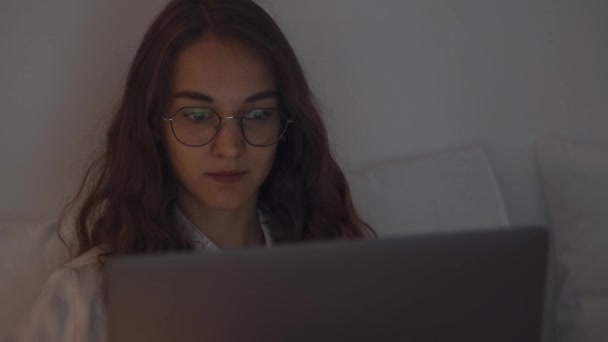Close Up młodej skoncentrowanej kobiety pracującej w nocy w sypialni przy użyciu laptopa — Wideo stockowe
