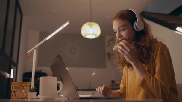 As mulheres trabalham à noite, comendo pizza, digitando no laptop e ouvindo música — Vídeo de Stock