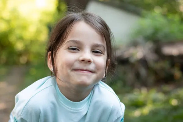 Bulanık kırsal arka planda, sevimli Bokeh 'le güzel, melez bir kızın yakın plan portresi.