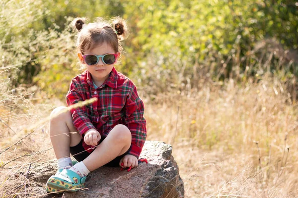 Liten Leende Rödhårig Flicka Solglasögon Och Hästsvansar Suddig Rustik Bakgrund — Stockfoto