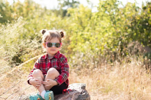 Mała Uśmiechnięta Ruda Dziewczyna Okularach Przeciwsłonecznych Kucykach Rozmytym Rustykalnym Tle — Zdjęcie stockowe