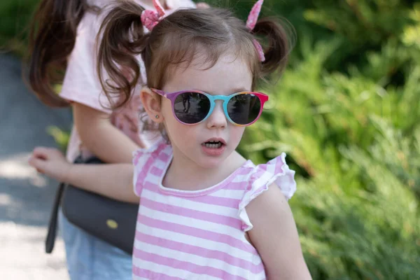 Erstaunliches Kleines Mädchen Mit Pferdeschwanz Und Sonnenbrille Auf Verschwommenem Natürlichen — Stockfoto