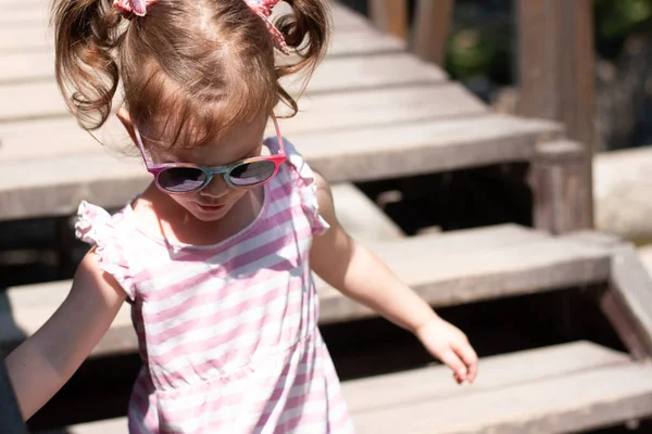 Piękna Dziewczynka Czerwonych Warkoczach Okularach Schodzi Schodach Drewnianego Mostu — Zdjęcie stockowe