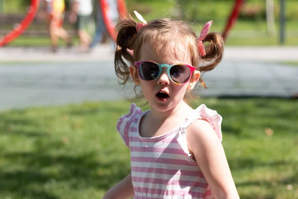 Aktywna Mała Piękna Dziewczyna Czerwonymi Warkoczami Okularami Przeciwsłonecznymi Sukienką Paski — Zdjęcie stockowe