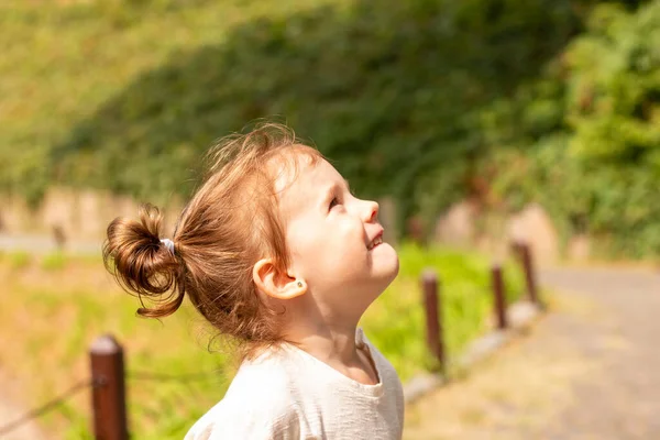 Pequena Garota Engraçada Olha Para Cima Enquanto Está Margem Uma Fotografias De Stock Royalty-Free