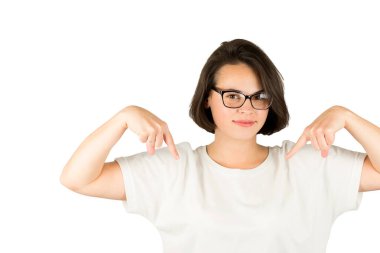 Stüdyo fotoğrafı beyaz tişörtlü, siyah pürüzsüz saçlı güzel bir kızın izole edilmiş arka planı parmaklarını işaret ediyor.