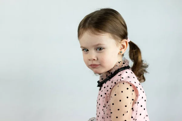 Little Girl Two Ponytails Dress Polka Dots White Background Sits — Stock Photo, Image