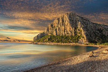 Akdeniz 'de gün batımında güzel kayalık bir sahil. Türkiye