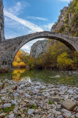Kokori 'nin sonbahar mevsiminde Zagori, Epirus Yunanistan' daki Voidomatis nehrinde yer alan eski kemer taşı köprüsü (Noutsos).
