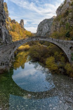Kokori 'nin sonbahar mevsiminde Zagori, Epirus Yunanistan' daki Voidomatis nehrinde yer alan eski kemer taşı köprüsü (Noutsos).