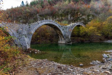 Kalogeriko (plakida), sonbahar mevsiminde Zagori, Epirus Yunanistan 'daki Voidomatis nehrinde yer alan eski kemer taşı köprüsü..