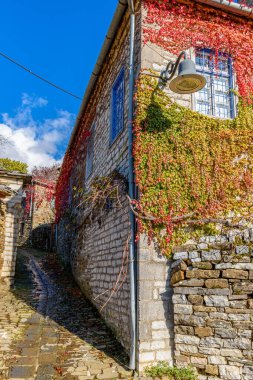 Epirus zagori Yunanistan 'ın pitoresk köyü Papigo' da sonbahar mevsiminde bir taş sokakta geleneksel mimarlık