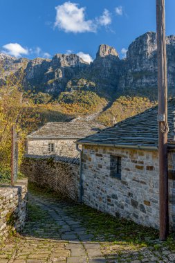 Yunanistan 'ın Zagori kentindeki papigo köyünde, sonbahar mevsiminde taştan binalar ve astraka arka planındaki geleneksel mimari manzarası