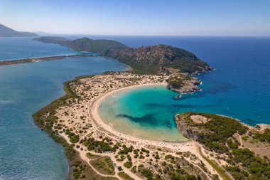 Messinia, Gialova, Moreloponnese, Yunanistan 'daki Voidokoilia' nın ikonik yarı dairesel kumlu plajının insansız hava aracı fotoğrafı