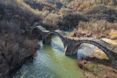 Kalogeriko (plakida), sonbahar mevsiminde Zagori, Epirus Yunanistan 'daki Voidomatis nehrinde yer alan eski kemer taşı köprüsü..