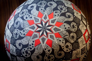 Soyut sembollü bir El boyalı seramik kürenin fotoğrafı.