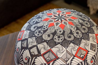 Soyut sembollü bir El boyalı seramik kürenin fotoğrafı.