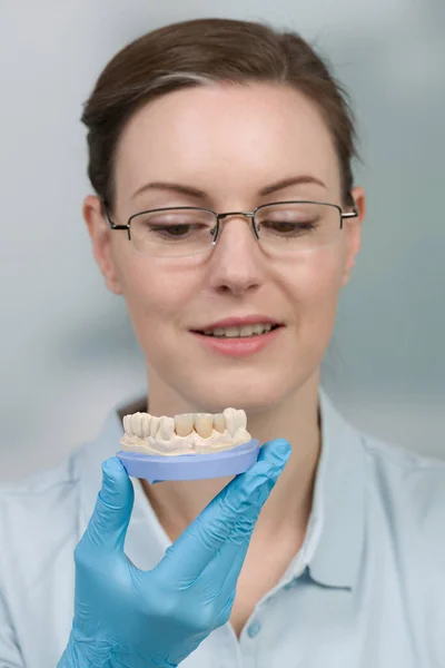 female dental technician works with denture parts in a dental laboratory