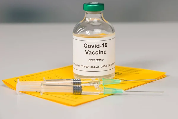 国际疫苗注射证明书及一瓶带有两个注射器的Covid 19疫苗的文件 — 图库照片