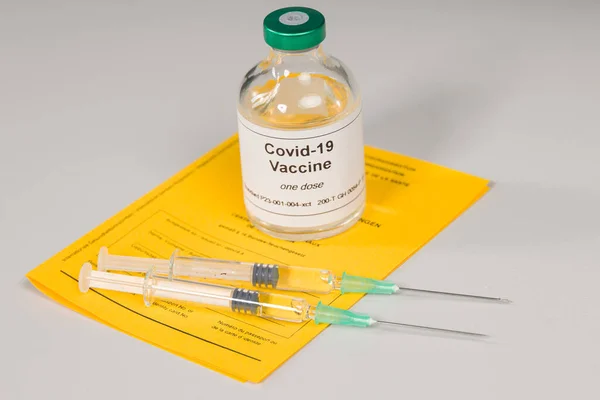 国际疫苗注射证明书及一瓶带有两个注射器的Covid 19疫苗的文件 — 图库照片
