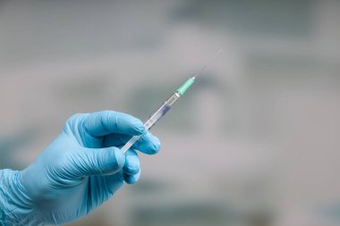 Doktorun elini tıbbî eldivenlerle kapat ve aşı için hazır bir şırınga getir. 