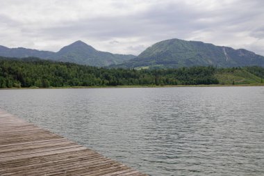 Önünde eski ahşap bir gölet olan göl manzarası