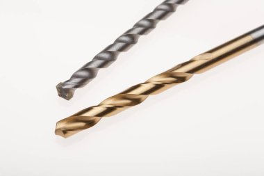 Beyaz bir yüzey üzerinde iki farklı matkap.