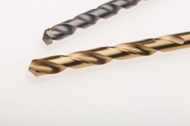 Beyaz bir yüzey üzerinde iki farklı matkap.