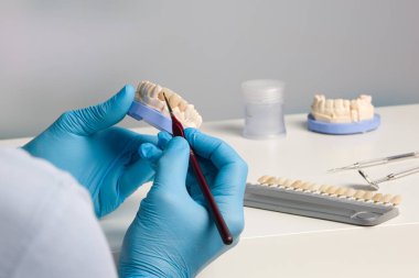 Diş teknisyeninin diş macunu üzerinde yaptığı çalışmalar yakın plan.