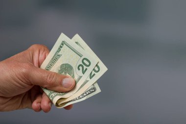 close-up of a man's hand holding a bunch of dollar bills / greenbacks