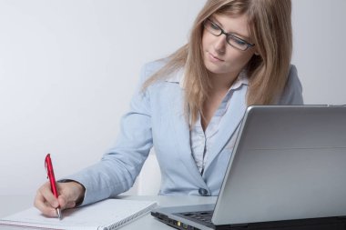 Merkez ofisteki genç iş kadını bilgisayarında çalışıyor.