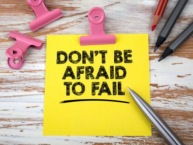 Başarısız olmaktan korkmayın. Not defteri ve ofis malzemeleri ahşap bir masada.