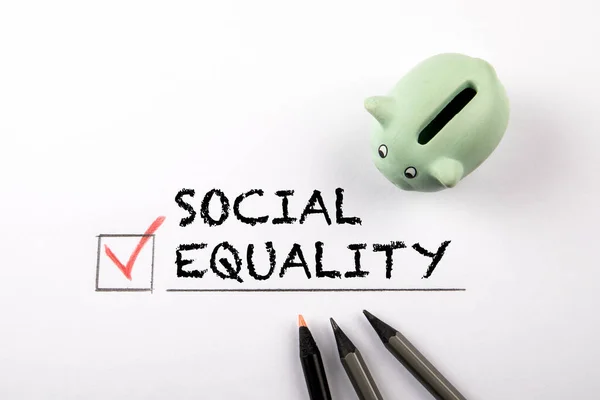 Igualdad social. Hucha y lápices sobre fondo blanco —  Fotos de Stock