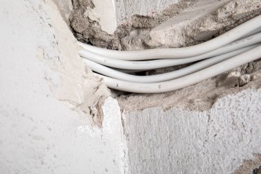 Duvara elektrik kabloları döşenmiş. Sıva ve inşaat alanı