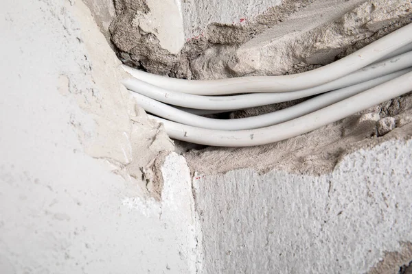 Duvara elektrik kabloları döşenmiş. Sıva ve inşaat alanı