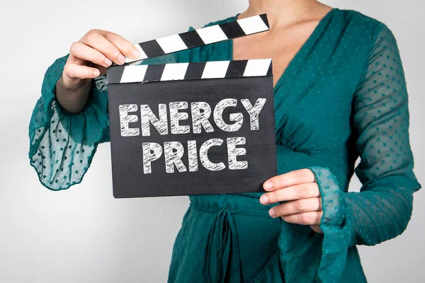 Energy Price. Woman hands holding black Clapperboard