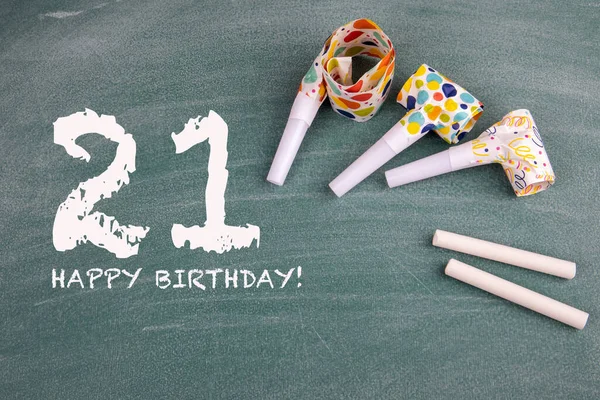 Celebrando 21 años de cumpleaños. Cumpleaños y silbatos de fiesta en un tablero verde — Foto de Stock