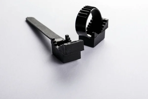 Two black wire clamps on a white background — Stock Photo, Image