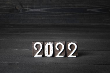 2022 Yeni Yıl. Koyu desenli ahşap zemin üzerinde tahta bloklar