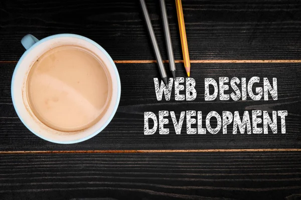 Desarrollo de Diseño Web. Taza de café y lápices de colores sobre un fondo de madera de textura negra — Foto de Stock